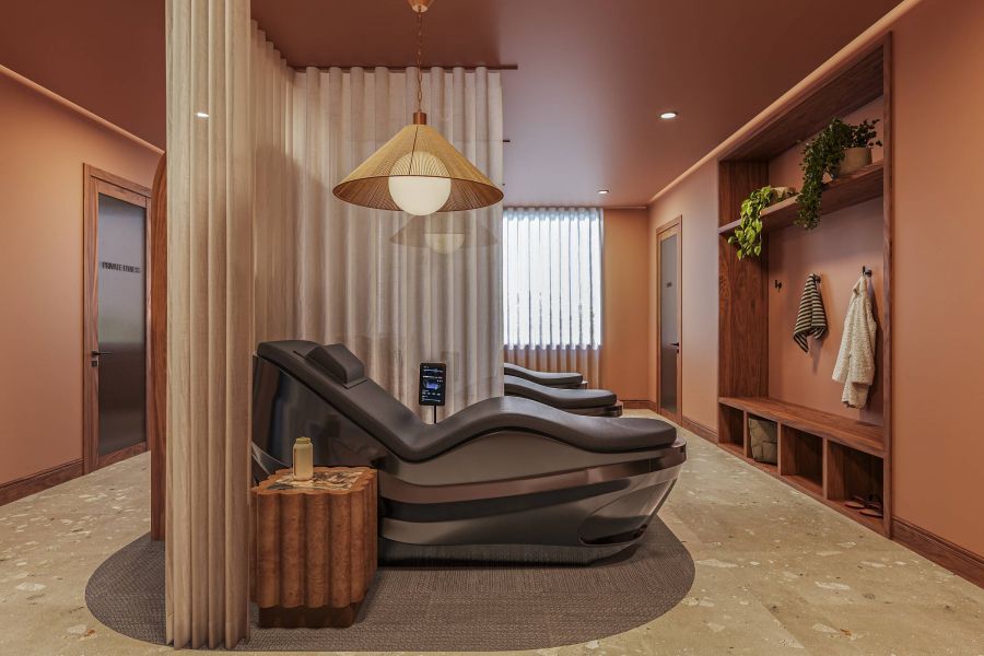 Ever College Station student living apartments Two modern lounge chairs in a warm-toned spa room with soft lighting, plants, and wooden decor elements.