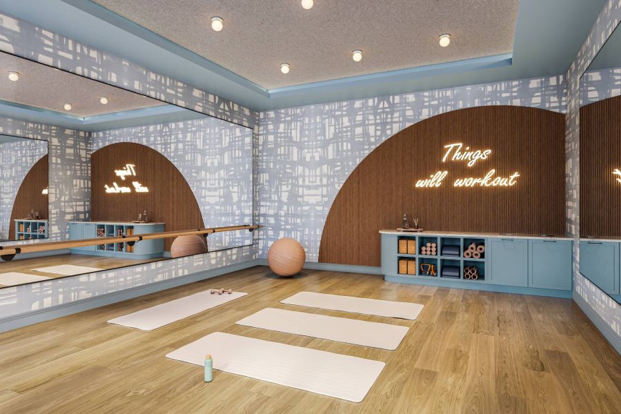 Ever College Station student living apartments Yoga studio with three mats, exercise balls, mirrors, and a neon sign that reads "Things will workout.