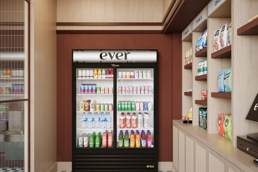 Ever College Station student living apartments A well-lit mini market with a beverage fridge and shelves stocked with snacks and groceries.