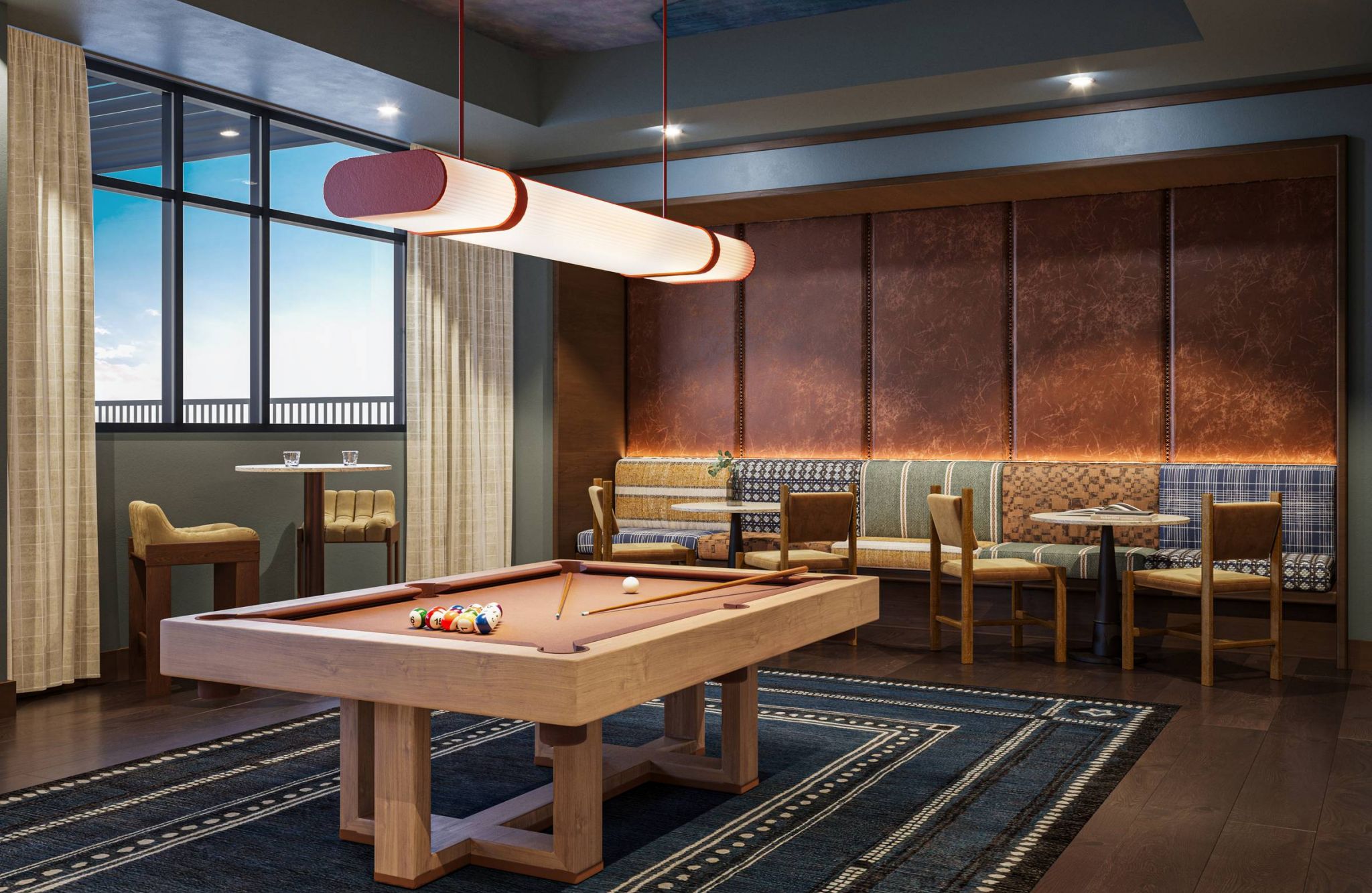 Ever College Station student living apartments Modern game room with a pool table, stylish lighting, seating area, and large windows with curtains.