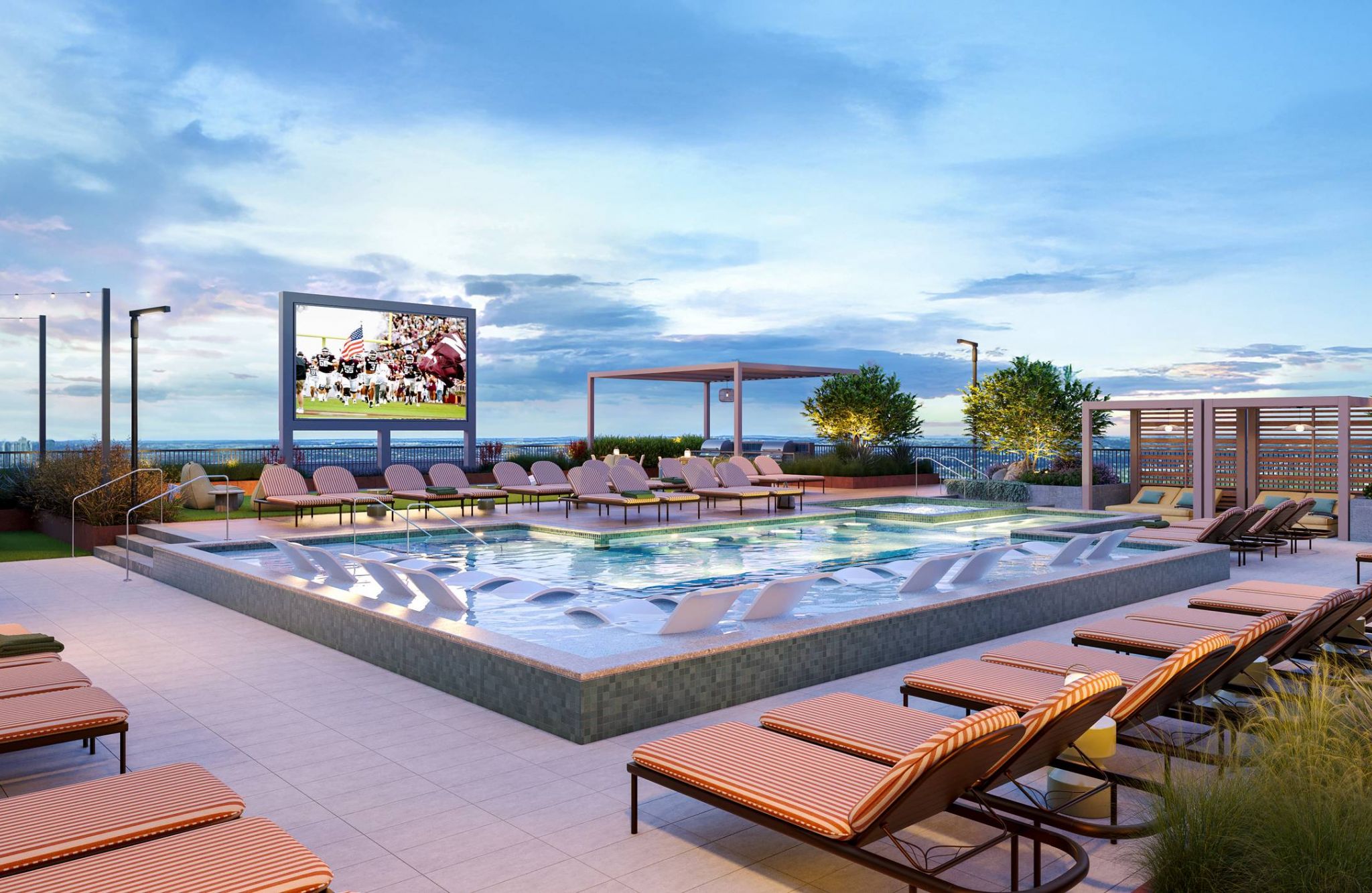 Ever College Station student living apartments Rooftop pool area with lounge chairs, a large outdoor TV screen, and a clear sky at sunset.