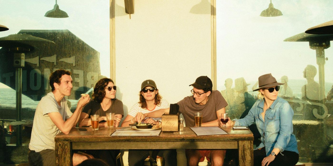 Group of college friends sharing drinks and laughs at an outdoor Northgate restaurant near Texas A&M campus